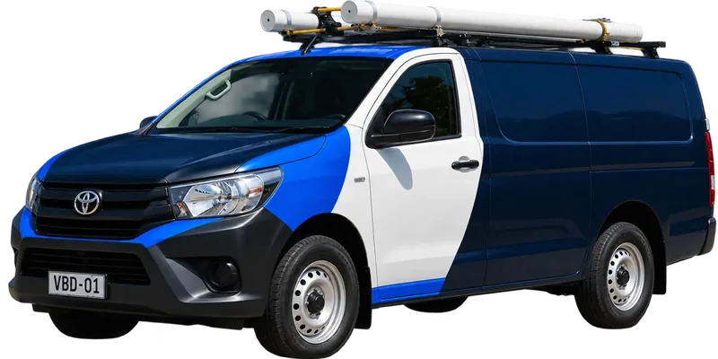 A licensed Hornsby plumbing van loaded with pipe on the roof rack
